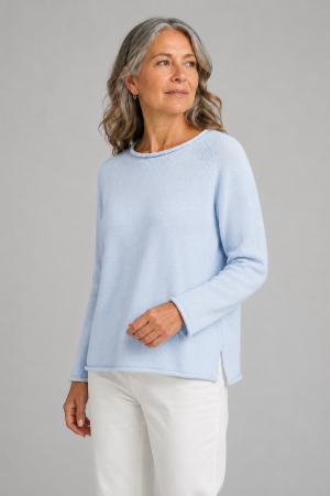 Older woman with shoulder-length gray hair in a light blue knit sweater with long sleeves