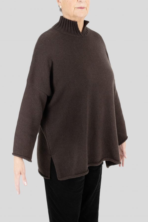 an oversized jumper featuring long sleeves, a high ribbed neckline, and a center front opening, presented in a chocolate colour, viewed from the side
