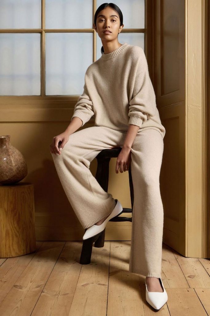 how to build a minimal cashmere wardrobe, folded various cashmere jumpers, woman wearing cashmere jumper and trousers