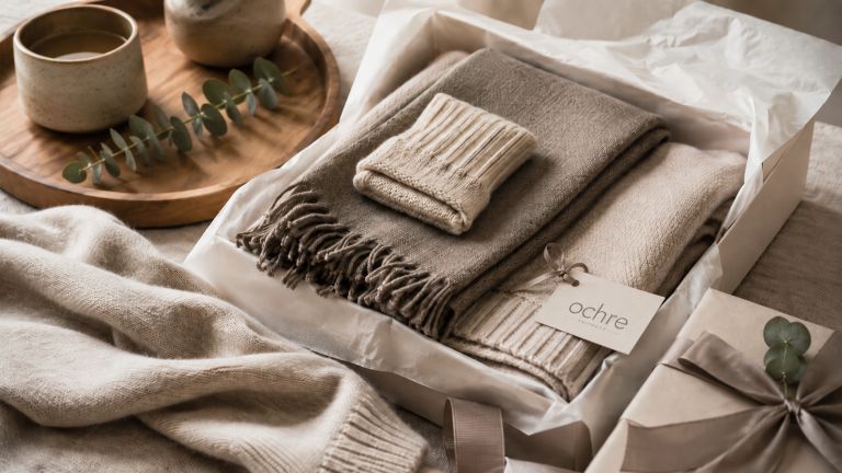 Luxury knitwear gift guide with cashmere wrap and natural fibre accessories arranged as thoughtful sustainable fashion gifts.