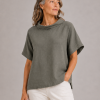 Harris-linen-funnel-neck-top-fir-green-model - Ochre Knitwear linen funnel neck top in fir green organic linen with folded collar and short sleeves, front view presented on women
