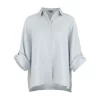 Linda-linen-shirt-pale blue-front-view - Ochre Knitwear Light blue button-down shirt on a torso mannequin with sleeves casually rolled up against a light gray background.