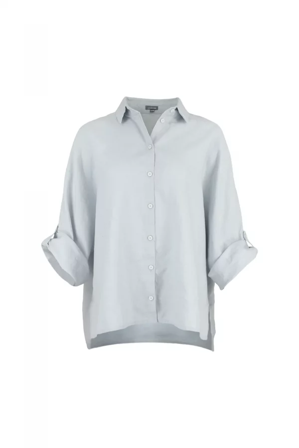 Linda-linen-shirt-pale blue-front-view - Ochre Knitwear Light blue button-down shirt on a torso mannequin with sleeves casually rolled up against a light gray background.