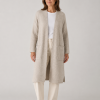 long yak wool cardigan with open front, dropped shoulders and two patch pockets, front view in stone colour, presented by middle age woman model