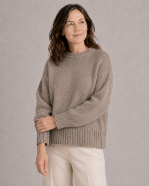 chunky yak crew neck jumper front view with dropped shoulders, full sleeves and deep ribbed hem presented by female mature woman