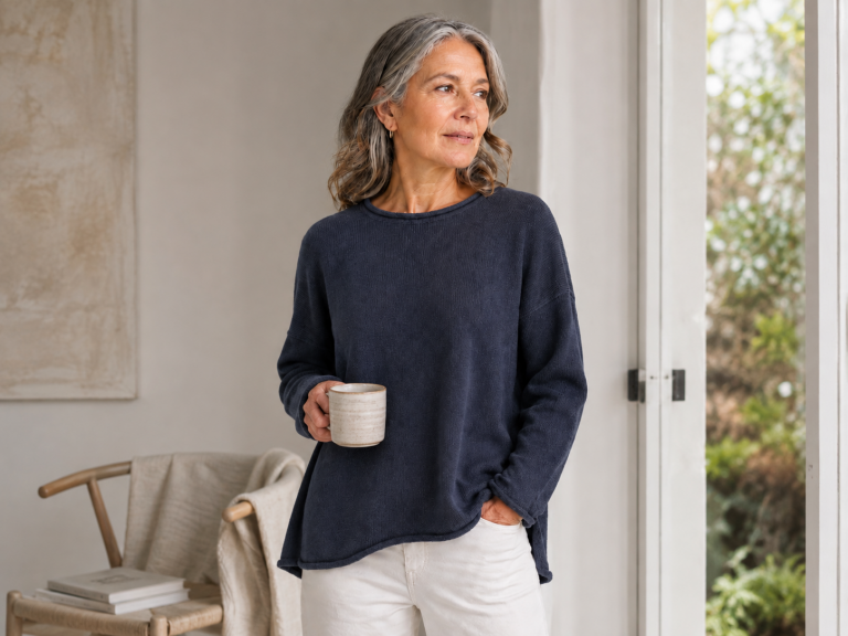 Organic cotton knitwear shown on a mature woman wearing an Ochre-inspired Jonah Organic Cotton Jumper with a wide rolled neckline, dropped shoulders and relaxed shape.