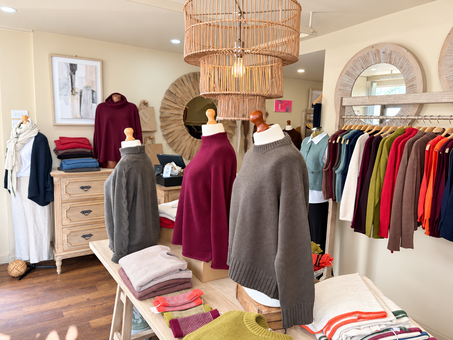 Grey and burgundy jumpers on mannequins beneath a wicker pendant at Ochre’s knitwear shop in Dartmouth.