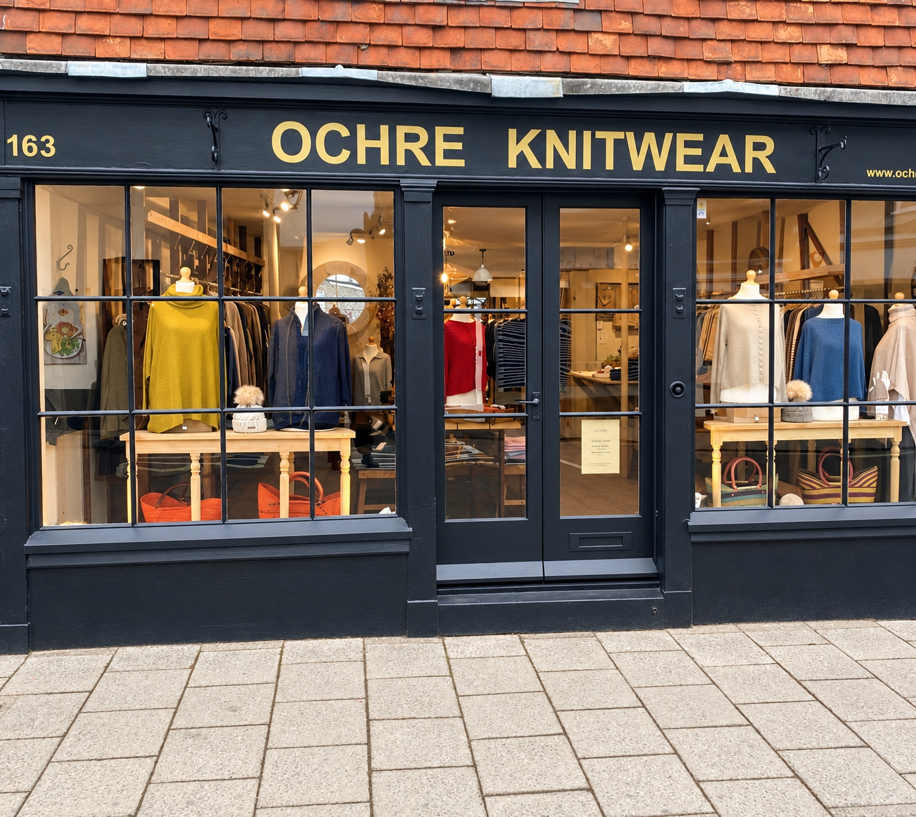 Ochre’s knitwear shop in Lewes with a charcoal shopfront, gold lettering and colourful window displays.